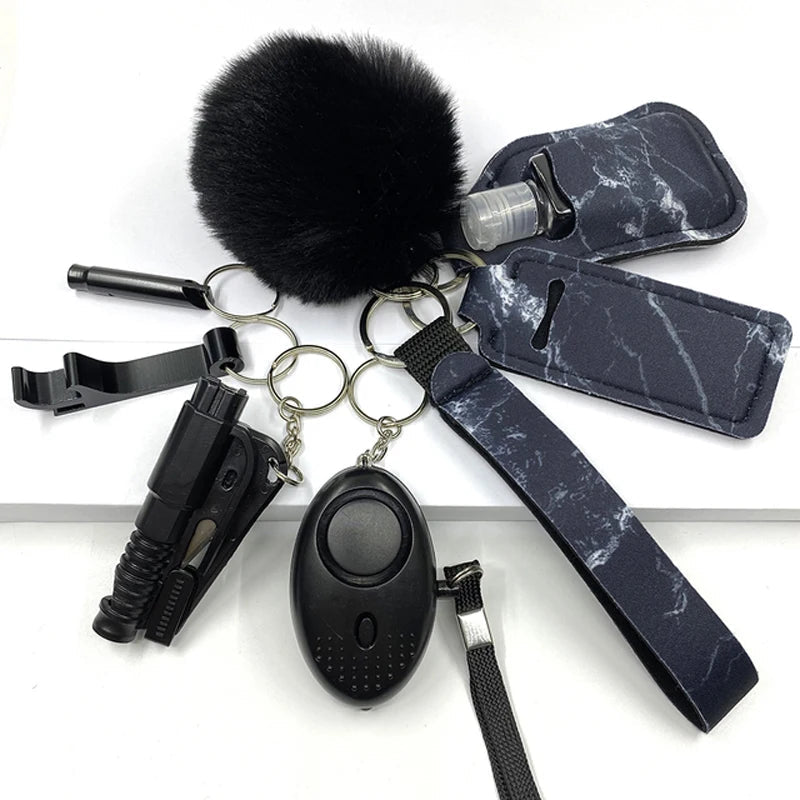 Image of the "SafetyKey set 8-delig," featuring a selection of self-defense tools attached to keyrings, including a black alarm device, a black flashlight, and black marble-patterned holders and accessories, designed with high-quality brass for women’s safety and protection.