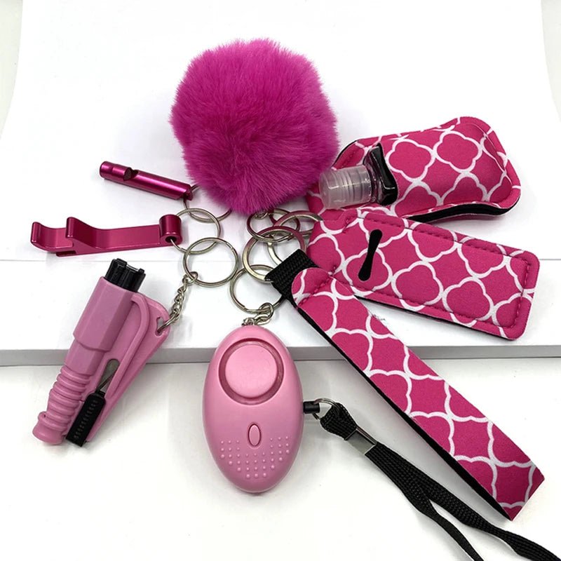 Set van 8 zelfverdedigingssleutelhangers met roze accessoires, inclusief pompon, persoonlijke alarm, flesopener, en andere veiligheidsartikelen.